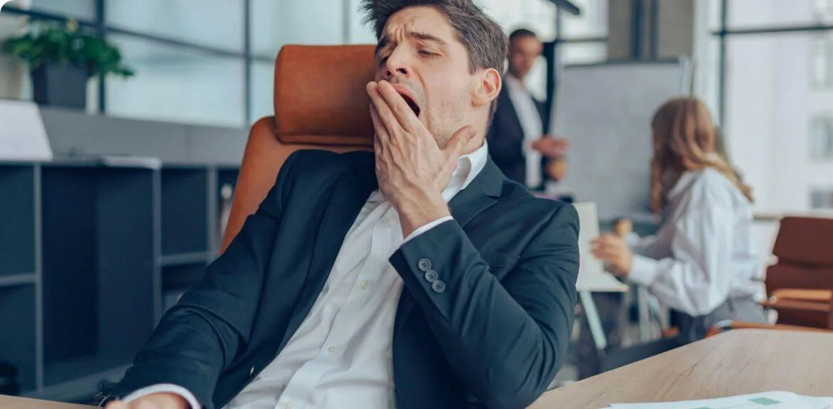 Mann erleidet an Müdigkeit als eins der Boreout Syndrom Symptome
