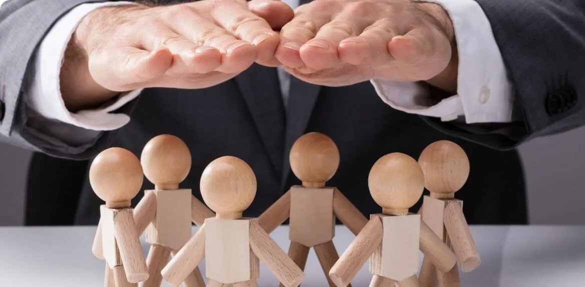 Hand über Mitarbeitern als Symbol der Fürsorgepflicht des Arbeitsgebers