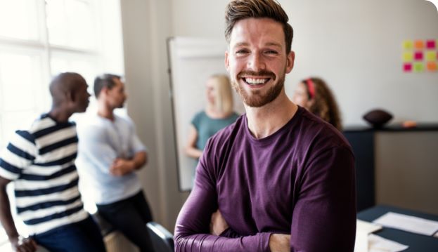 Zufriedener Mitarbeiter schaut in die Kamera