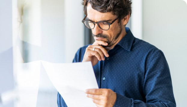 Mann mit Brille liest sich Arbeitsvertrag durch