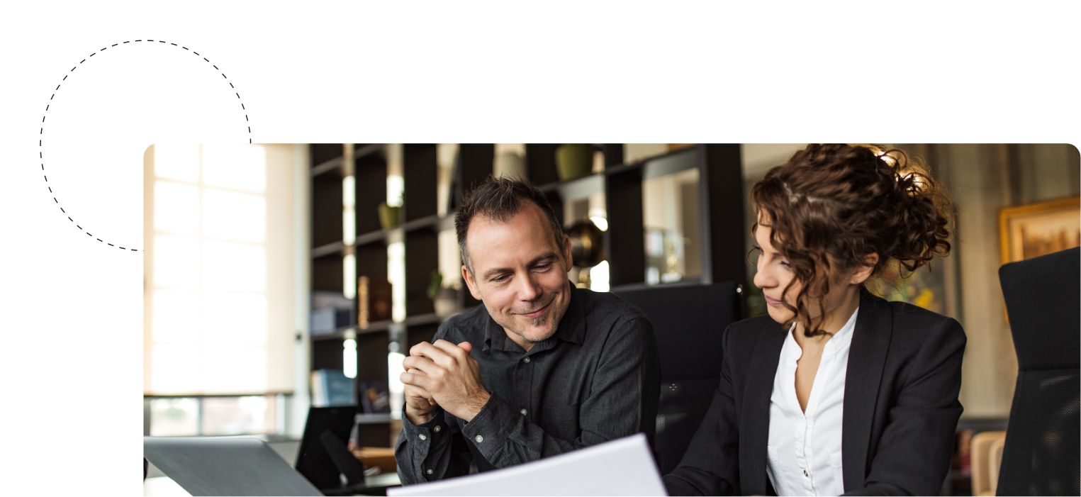 Zwei Businessleute diskutieren über einen Lebenslauf gebeugt.