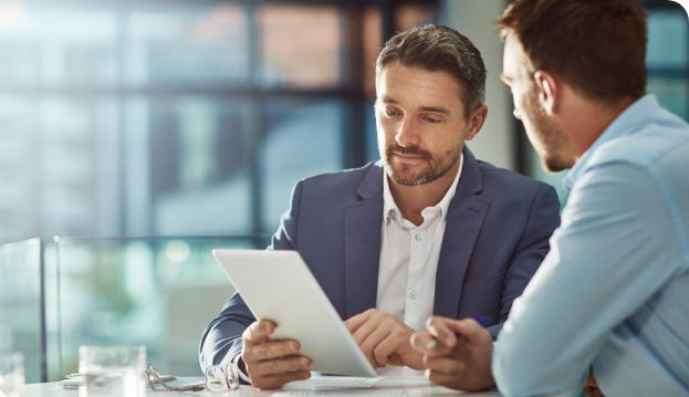 Mann mit Tablet bespricht den Aufbau der Arbeitgebermarke mit einem Kollegen